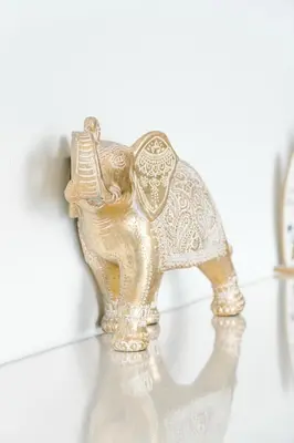 a gold elephant statue sitting on a shelf at Casa Lapa Roja in Playa Hermosa