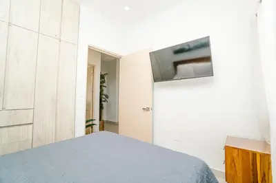 a bedroom with a bed and a tv on a wall at Casa Lapa Roja in Playa Hermosa