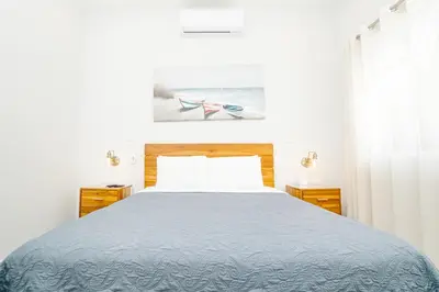 a bedroom with a large bed with a blue blanket at Casa Lapa Roja in Playa Hermosa