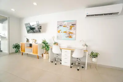 a white office with a desk and two chairs at Casa Lapa Roja in Playa Hermosa