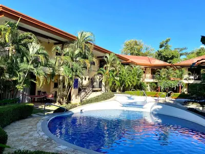 a swimming pool in front of a house at Jaco Hideaway Oasis in Jacó