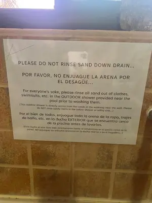 a sign in a bathroom that says please do not rinse sand down drain at Jaco Hideaway Oasis in Jacó