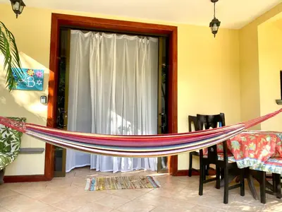 a hammock in a living room with a window at Jaco Hideaway Oasis in Jacó