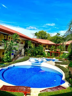 a large blue swimming pool in front of a house at Jaco Hideaway Oasis in Jacó