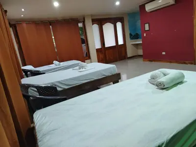 two beds with towels on them in a room at Bioluminiscencia Hostel Tours - South in Paquera