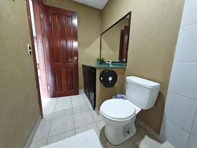 a bathroom with a toilet and a sink and a mirror at Bioluminiscencia Hostel Tours - South in Paquera