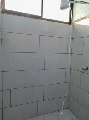 a white tiled shower with a window in a bathroom at Casa Beli in Monteverde Costa Rica