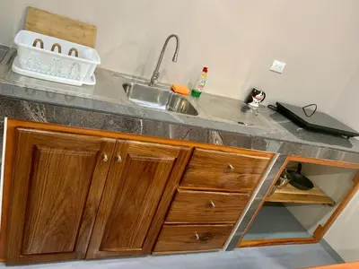 a kitchen counter with a sink and wooden cabinets at Verde Amanecer in Bijagua
