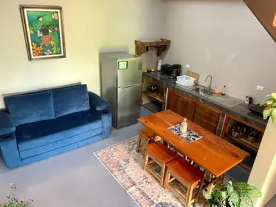 a living room with a blue couch and a table at Verde Amanecer in Bijagua