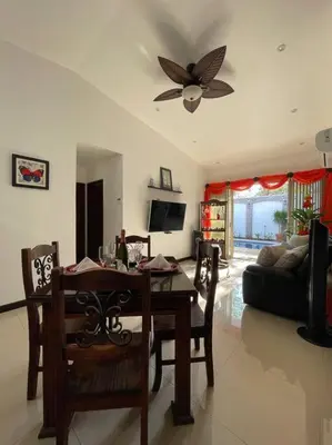 a living room with a dining table and a ceiling fan at Casa Encanto Luz del Mar, Con Piscina Privada in Herradura