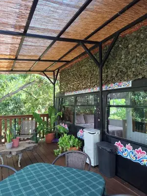an outdoor patio with a table and chairs at Casa Bus los Guanacastes in Veintisiete de Abril
