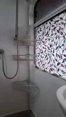 a bathroom with a window with a shower curtain at Casa Bus los Guanacastes in Veintisiete de Abril