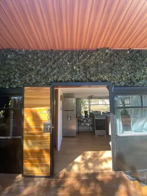 a house with a patio with an orange roof at Casa Bus los Guanacastes in Veintisiete de Abril