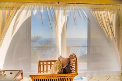 a wicker chair sitting in front of a window at Villa Amor del Mar with Breathtaking View of Ocean & Jungle in Dominical