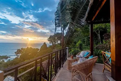 a balcony of a house with a view of the ocean at Villa Amor del Mar with Breathtaking View of Ocean & Jungle in Dominical