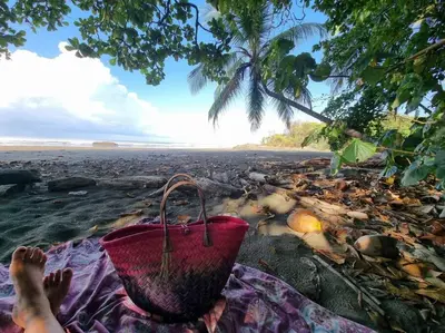 a person laying on the beach with a basket at Villa Amor del Mar with Breathtaking View of Ocean & Jungle in Dominical