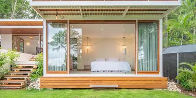 a bedroom in a glass house with a bed at Villa Laia - Santa Teresa in Santa Teresa Beach