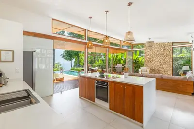 an open kitchen and living room with large windows at Villa Laia - Santa Teresa in Santa Teresa Beach