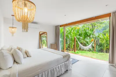 a bedroom with a bed and a large window at Villa Laia - Santa Teresa in Santa Teresa Beach