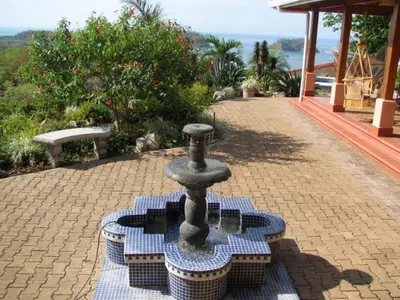 a small fountain sitting on a brick walk way at PACIFIC VISTA, Panoramic Beach & Ocean Views in Sámara