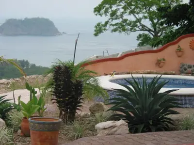 a garden with a swimming pool and some plants at PACIFIC VISTA, Panoramic Beach & Ocean Views in Sámara