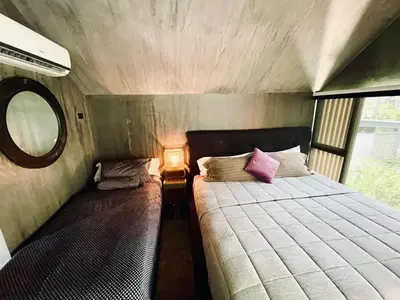 a small bedroom with a bed and a lamp at Studio Aloha - Malpais in Carmen