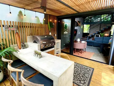 a patio with a table and a grill and a living room at Studio Aloha - Malpais in Carmen