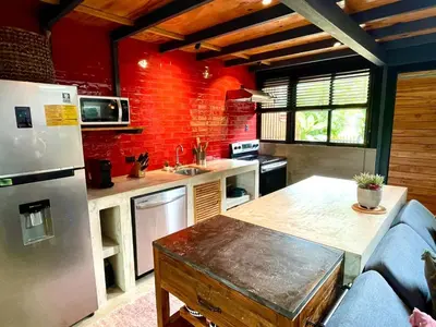 a kitchen with a refrigerator and a table in it at Studio Aloha - Malpais in Carmen