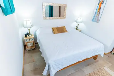 a bedroom with a white bed and two lamps at Hacienda La Norma Boho Boutique Hotel in Veintisiete de Abril