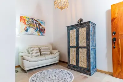 a living room with a couch and a cabinet at Hacienda La Norma Boho Boutique Hotel in Veintisiete de Abril