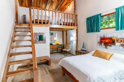 a bedroom with a loft bed and a staircase at Hacienda La Norma Boho Boutique Hotel in Veintisiete de Abril