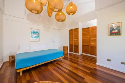 a bedroom with a bed and wooden floors and lights at Villa Flamingo 8 At Playa Flamingo in Playa Flamingo