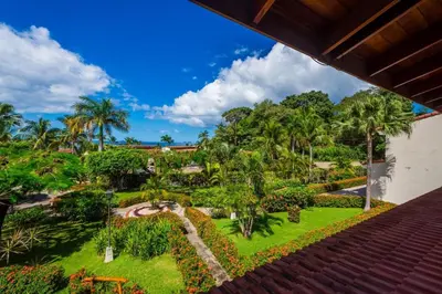 a view of the garden from the balcony of a resort at Villa Flamingo 8 At Playa Flamingo in Playa Flamingo
