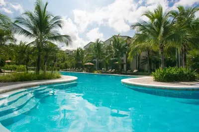 a swimming pool with palm trees in a resort at Classy artsy ocean-view unit near pool at Pacifico in Coco sleeps 6 in Coco