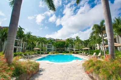 a pool at the resort with palm trees at Classy artsy ocean-view unit near pool at Pacifico in Coco sleeps 6 in Coco