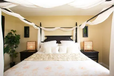a bedroom with a large white bed with two lamps at Classy artsy ocean-view unit near pool at Pacifico in Coco sleeps 6 in Coco