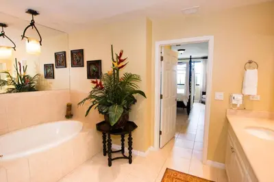 a bathroom with a tub and a plant on a table at Classy artsy ocean-view unit near pool at Pacifico in Coco sleeps 6 in Coco