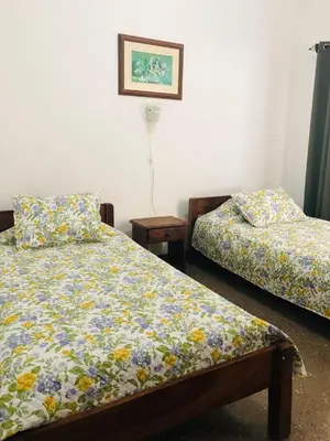 a bedroom with two beds and a picture on the wall at Hotel Del Aserradero in Liberia