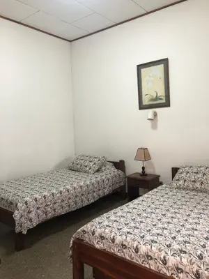 a room with two beds and a picture on the wall at Hotel Del Aserradero in Liberia
