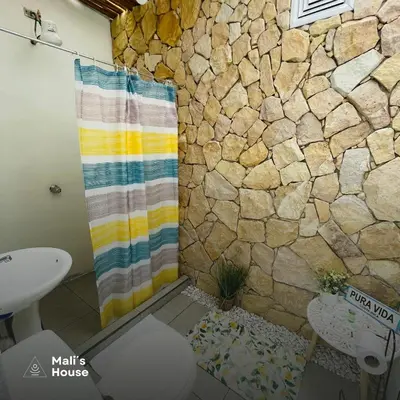 a bathroom with a shower with a stone wall at Mali's House in Fortuna