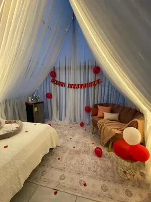 a bedroom with a bed and a couch and red decorations at Mali's House in Fortuna