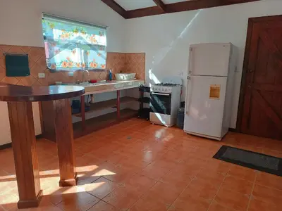 a kitchen with a counter and a refrigerator and a sink at House Manantial de Vida in Nandayure