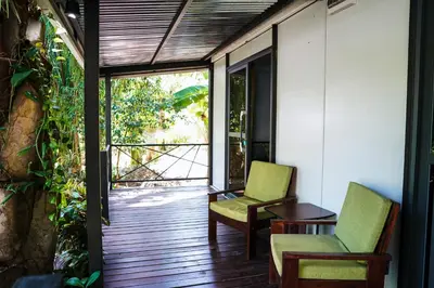 a room with two chairs and a table on a porch at House in the palm forest in Carrillo