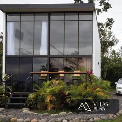 a house with a lot of windows and plants in front of it at Villa Aura in Fortuna