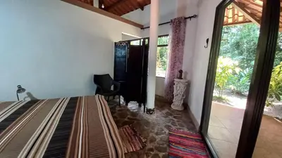 a bedroom with a bed and a large window at Cosy Apartment near the Lake in Tilarán