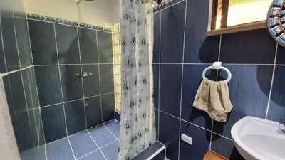 a bathroom with a shower and a sink at Cosy Apartment near the Lake in Tilarán