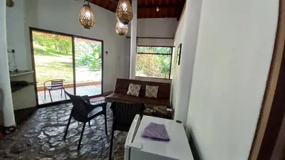 a living room with a couch and a table and chairs at Cosy Apartment near the Lake in Tilarán