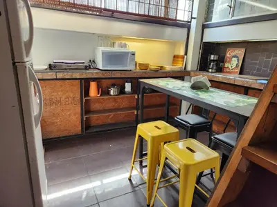 a kitchen with a counter and two yellow stools at Edificio El Barrio Vertical in San José