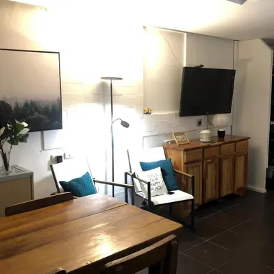 a living room with a wooden table and a flat screen tv at Edificio El Barrio Vertical in San José