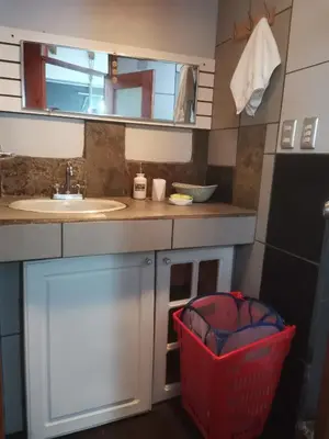 a small kitchen with a sink and a laundry basket at Edificio El Barrio Vertical in San José